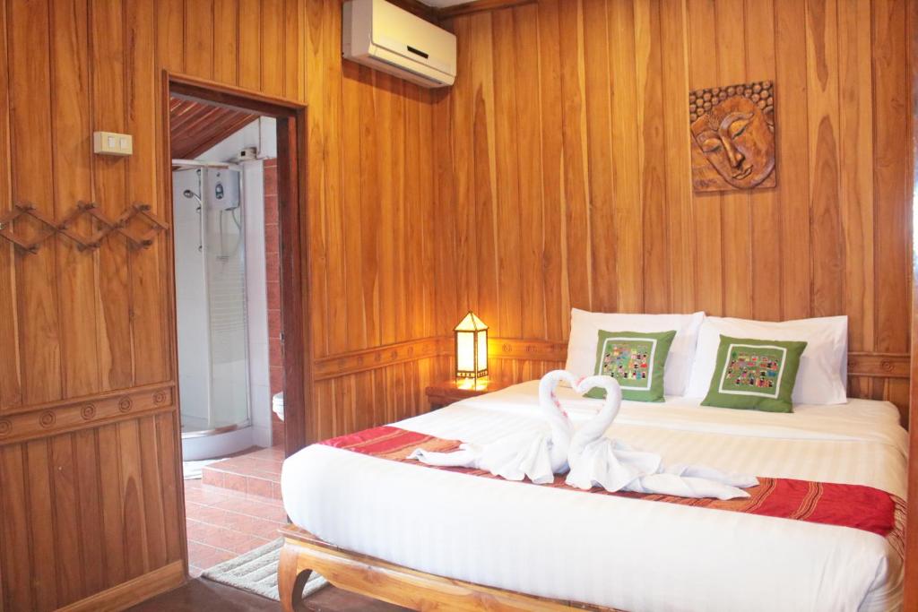 ein Schlafzimmer mit einem Bett mit zwei Schwänen darauf in der Unterkunft Apple Guesthouse in Luang Prabang