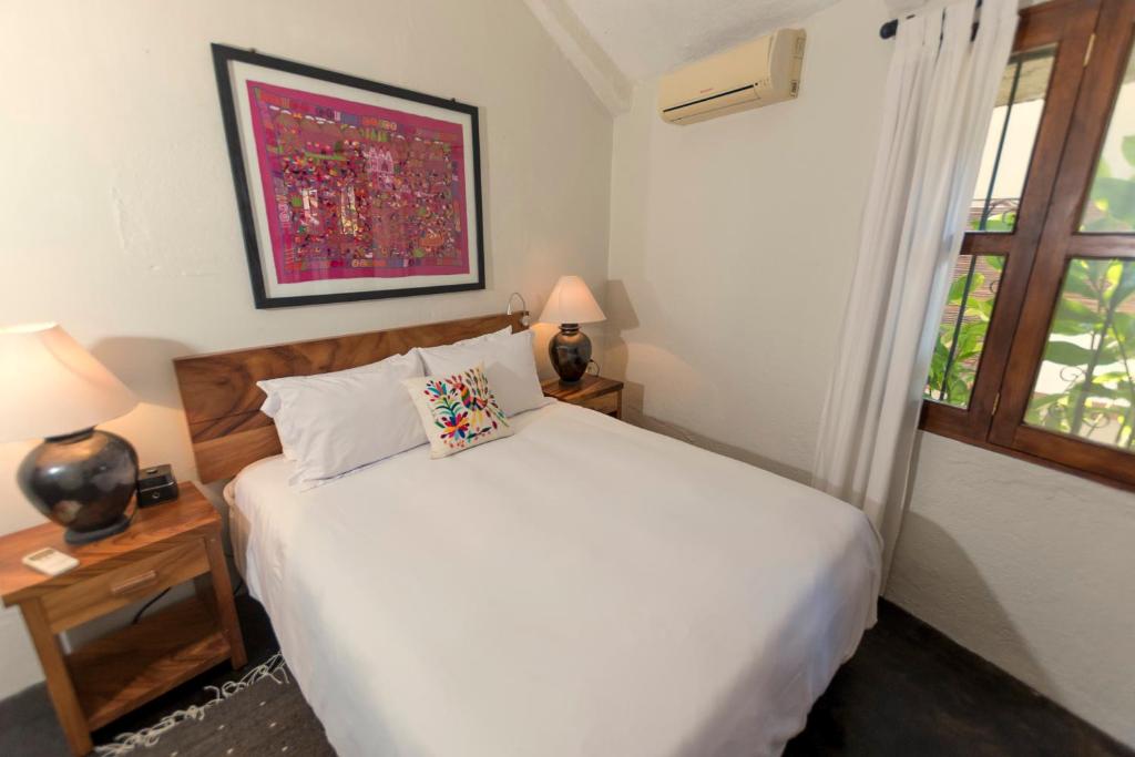 a bedroom with a white bed and a window at Villas Carrizalillo in Puerto Escondido