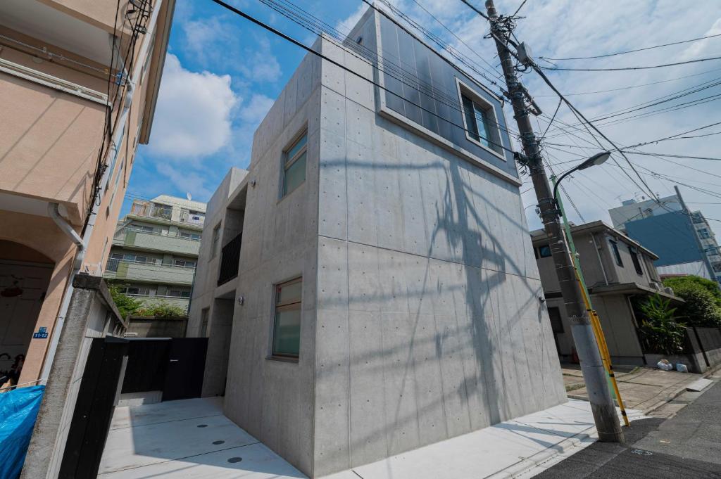 un edificio con una sombra a su lado en bmj Hyakunincho, en Tokio
