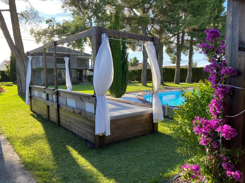a backyard pool with a pergola and a swing at VILLA SA CALMA in Zaragoza