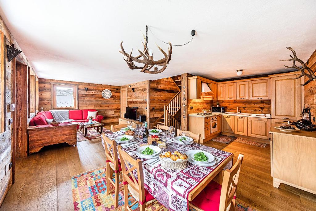 een keuken en eetkamer met een tafel en stoelen bij Chalet Resort Sozzine in Ponte di Legno