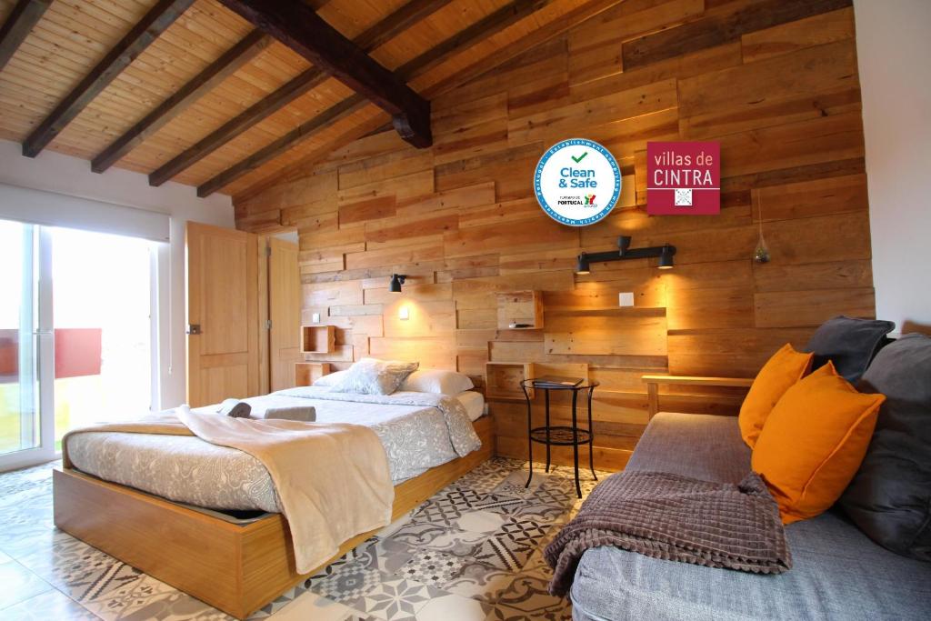 1 dormitorio con 2 camas y reloj en la pared en Villas de Cintra en Sintra