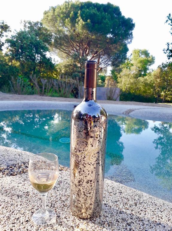 - une bouteille de vin et un verre près de la piscine dans l'établissement Le Mas de Cocody, au Plan-de-la-Tour