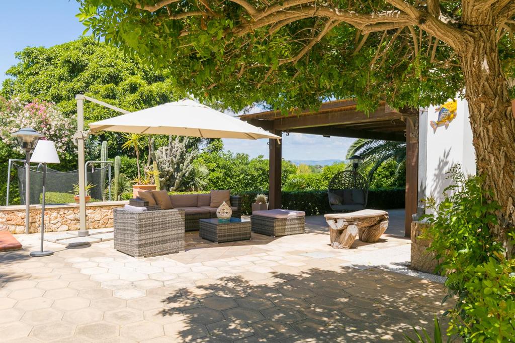 a patio with a couch and an umbrella at Villa Plemmyria in Syracuse