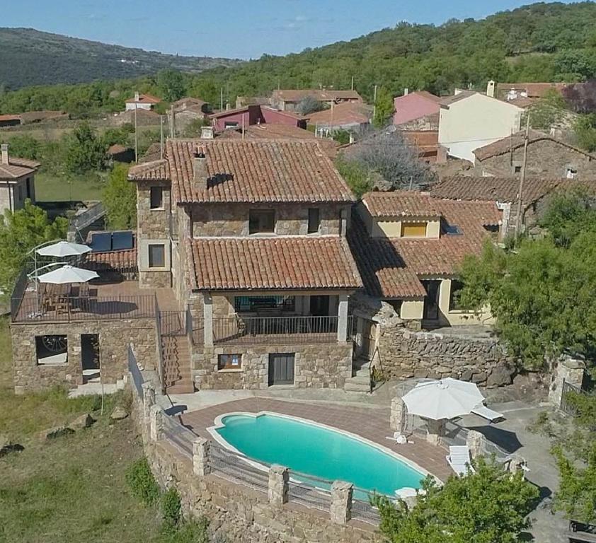 uma vista exterior de uma casa com piscina em Casas Rurales Lalo y Chelo em La Aldehuela