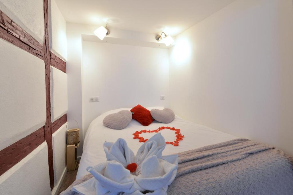 Un dormitorio con una cama con toallas y una flor. en La stub de la Petite Venise, en Colmar