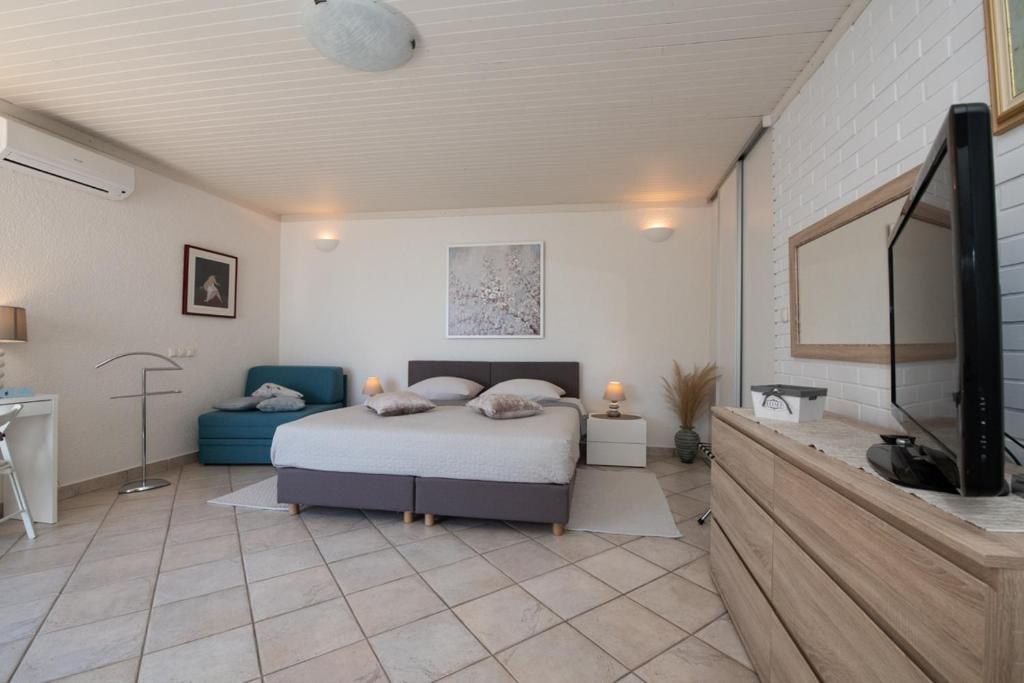 sypialnia z łóżkiem i telewizorem z płaskim ekranem w obiekcie Villa Tomić Apartment Mia near the sea w mieście Opatija