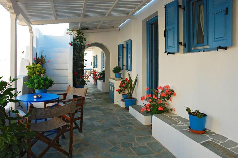 - une terrasse avec une table, des chaises et des fleurs dans l'établissement Artemis Rooms, à Folégandros