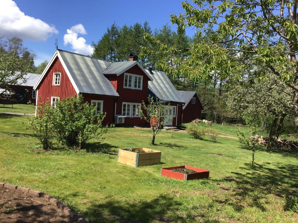 un granero rojo con dos cajas en el patio en Stuga nära Ullared en Ullared