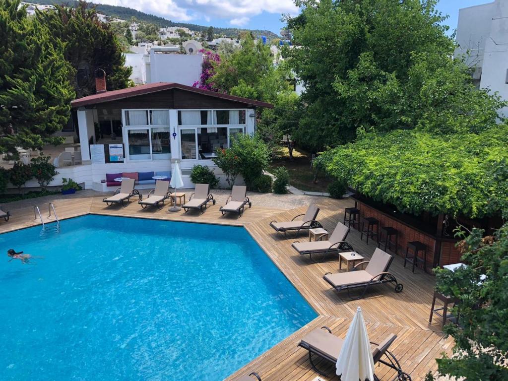 a swimming pool with chaise lounges and chairs on a deck at Costa Bodrum City in Bodrum City