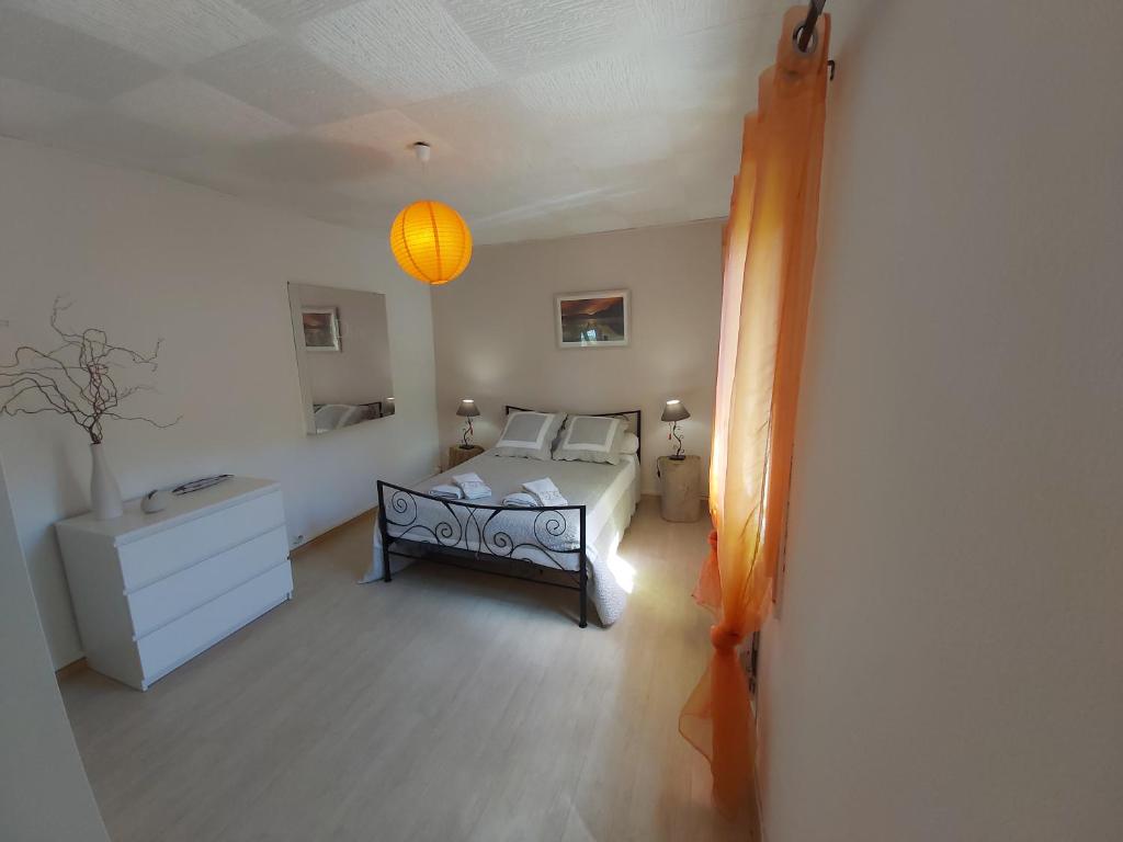 ein Schlafzimmer mit einem Bett, einer Kommode und einer Lampe in der Unterkunft les théolats in Rochefort-en-Valdaine