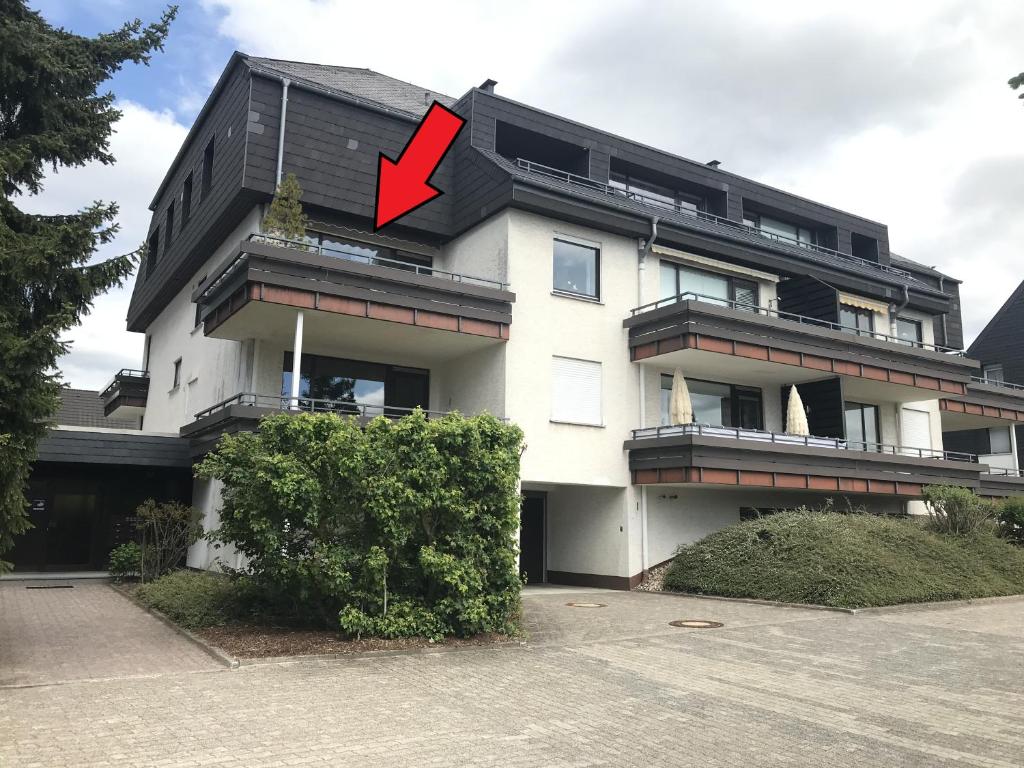 a white building with a red arrow pointing to it at Ferienwohnung Heidi Winterberg in Winterberg
