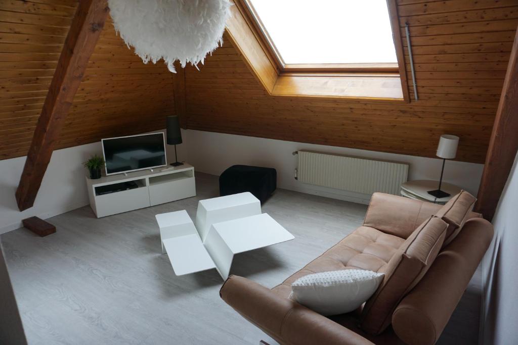 a living room with a couch and a tv at Studio Maujobia 31 in Neuchâtel