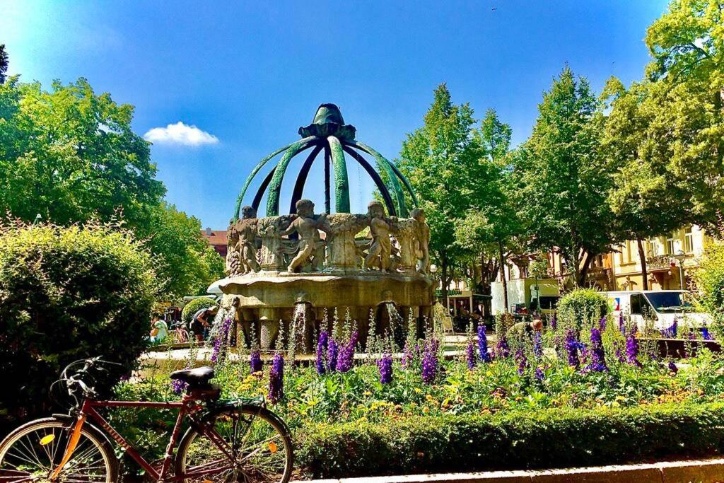 a bike parked in front of a fountain at Altbauwohnung am Gutenbergplatz in Karlsruhe