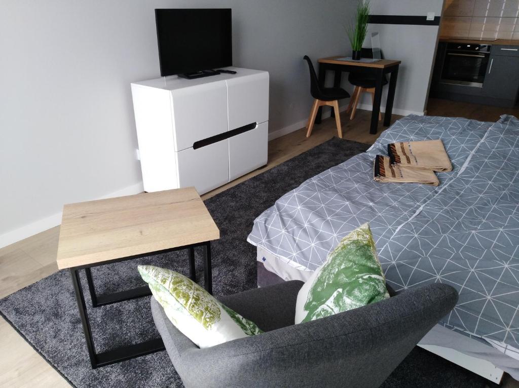 sala de estar con cama y silla en Apartament w centrum Szczecina, en Szczecin