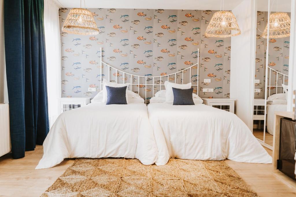 Hotel Mar Azul & Surf في سوانسيس: غرفة نوم مع سرير أبيض كبير مع وسائد زرقاء