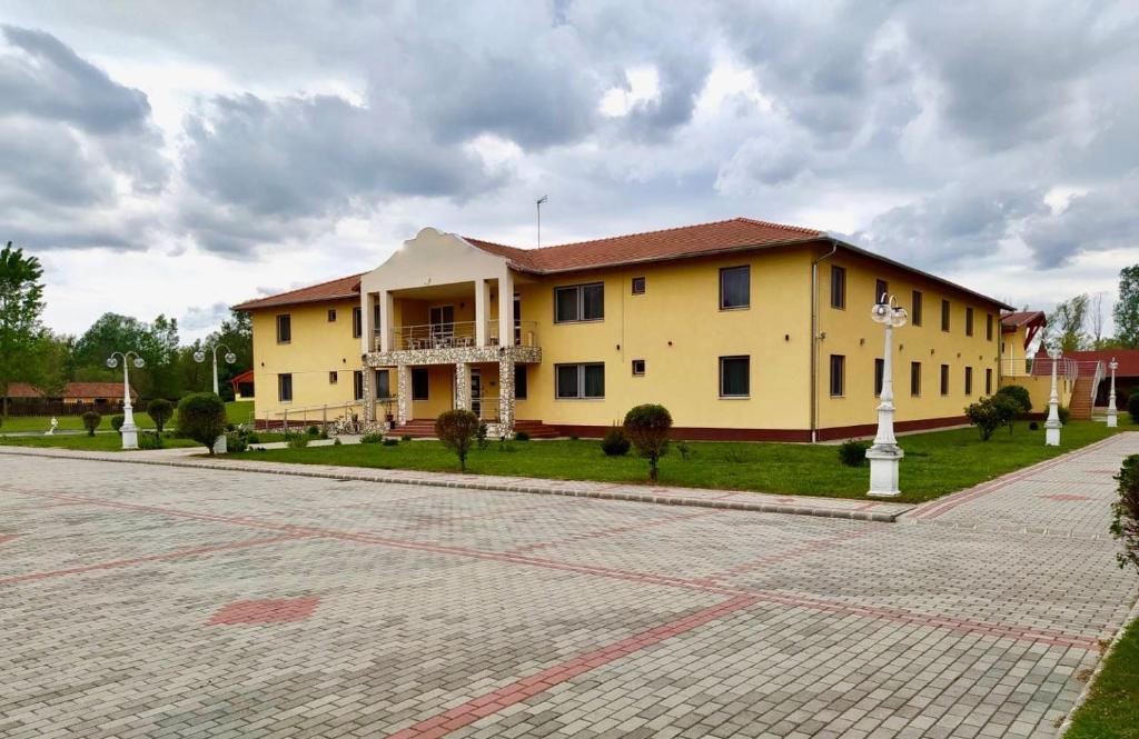 a large yellow building on the side of a street at Ligetalja Termál Hotel in Penészlek