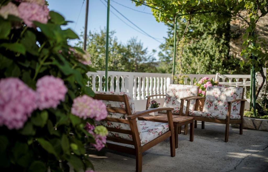 eine Gruppe Stühle, ein Tisch und Blumen in der Unterkunft Holiday House Predrag in Rab