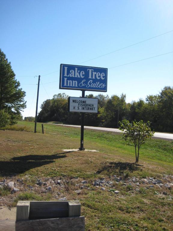 una señal para una posada y suites en un árbol del lago en Lake Tree Inn &amp; Suites, en Marion