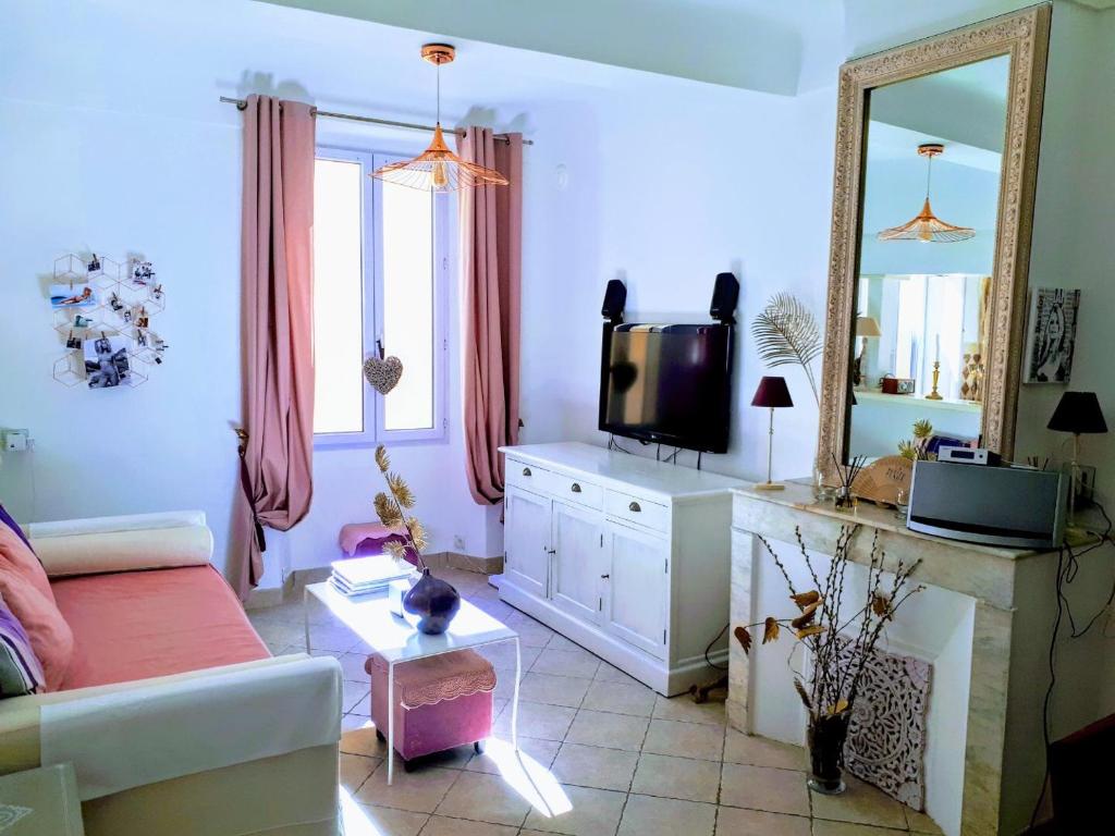a living room with a couch and a mirror at Appartement de charme au coeur de Saint-Tropez in Saint-Tropez