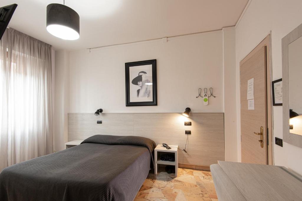 sypialnia z dużym łóżkiem i oknem w obiekcie Hotel Careggi we Florencji
