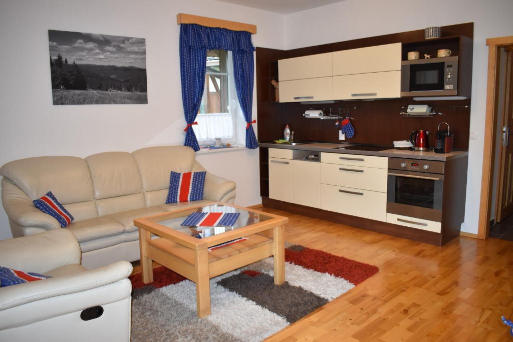 ein Wohnzimmer mit einem Sofa und einem Tisch in der Unterkunft Apartman Razula in Velké Karlovice