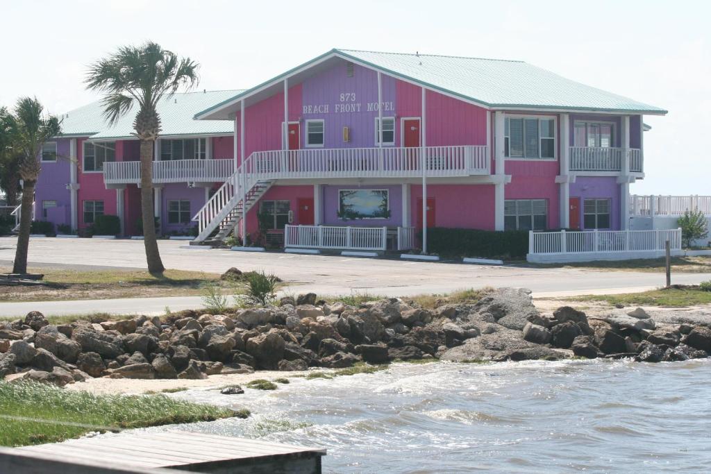 un edificio rosa accanto a un corpo d'acqua di Beach Front Motel Cedar Key a Cedar Key