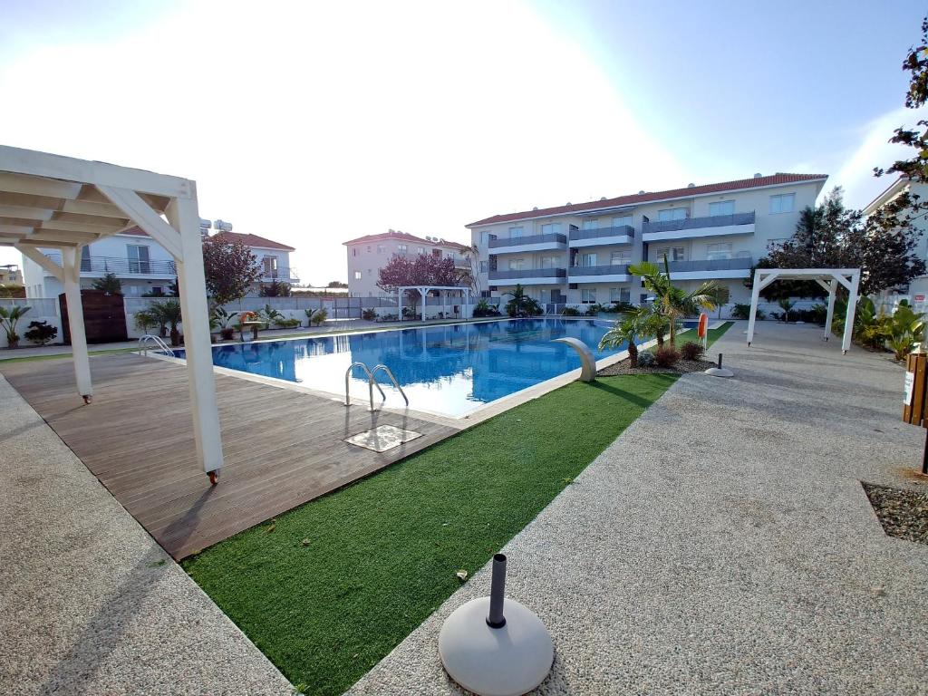 una piscina con parque infantil frente a un edificio en AP10 Mythical Sands, en Protaras