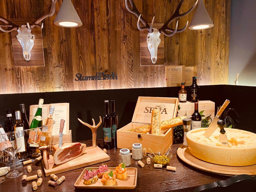 a table with bottles of wine and a box of food at Hotel Central in Gerlos