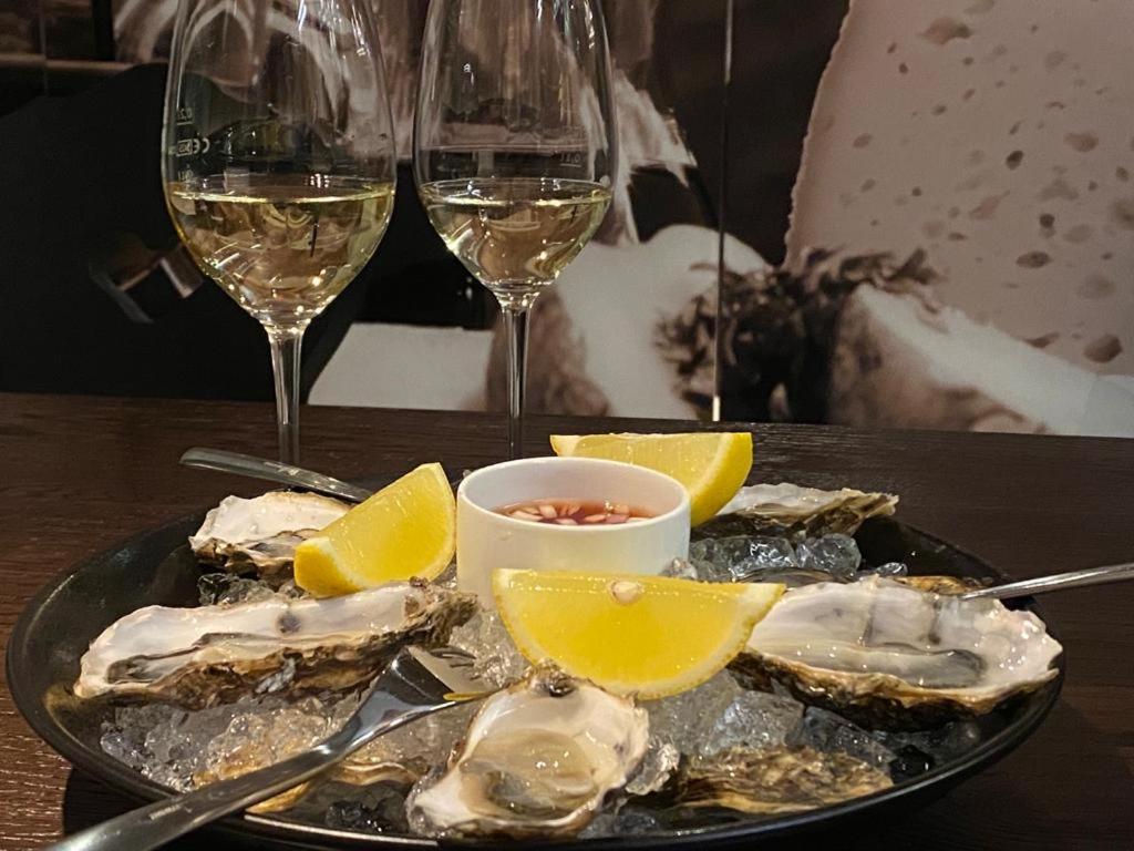 a plate of oysters and glasses of wine on a table at Hotel Central in Gerlos