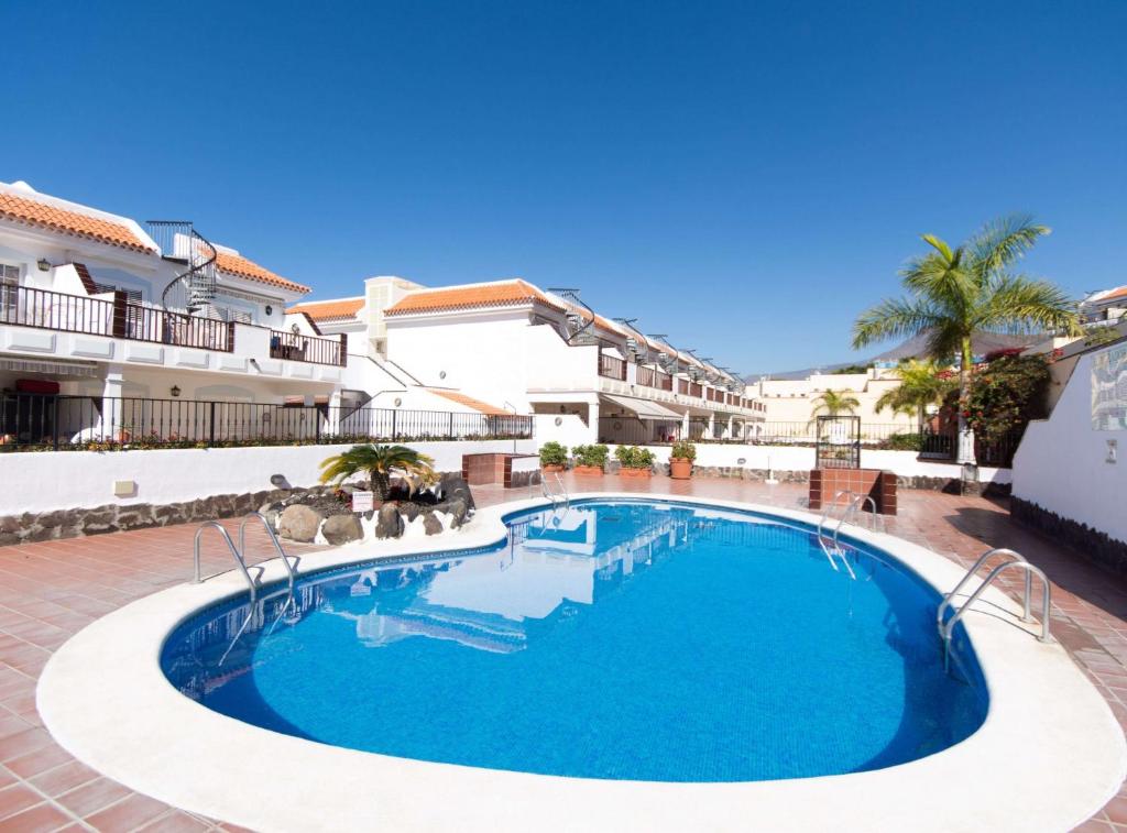 a swimming pool in front of a building at Fewo Jacqui in Los Cristianos