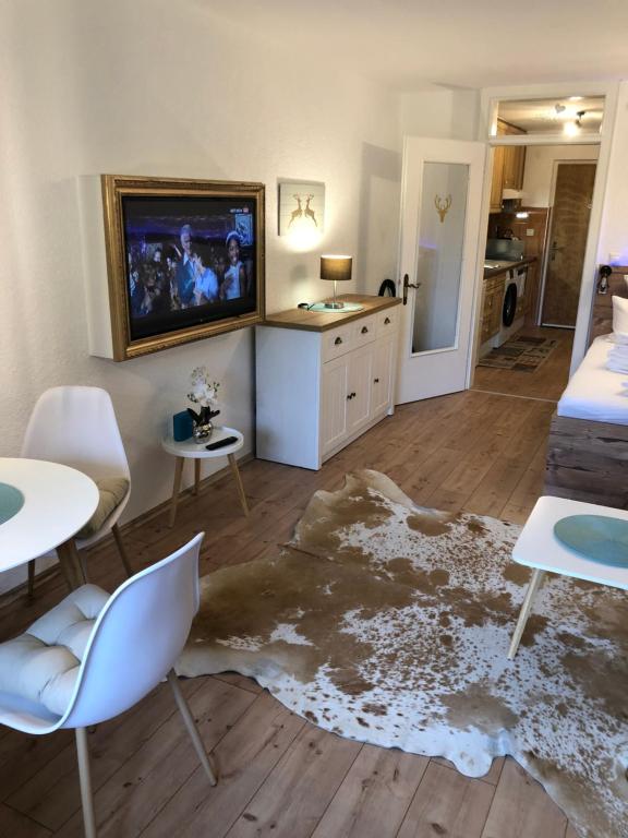 salon z telewizorem, stołem i krzesłami w obiekcie Apartment Haus Föhrenwald w mieście Seefeld in Tirol