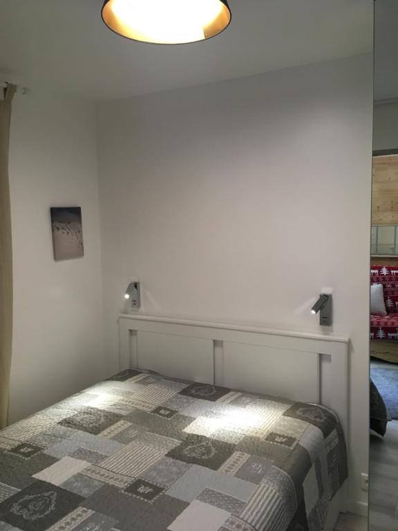 a bedroom with a bed and a light above it at les Cimes d'Or Mont blanc in Les Contamines-Montjoie