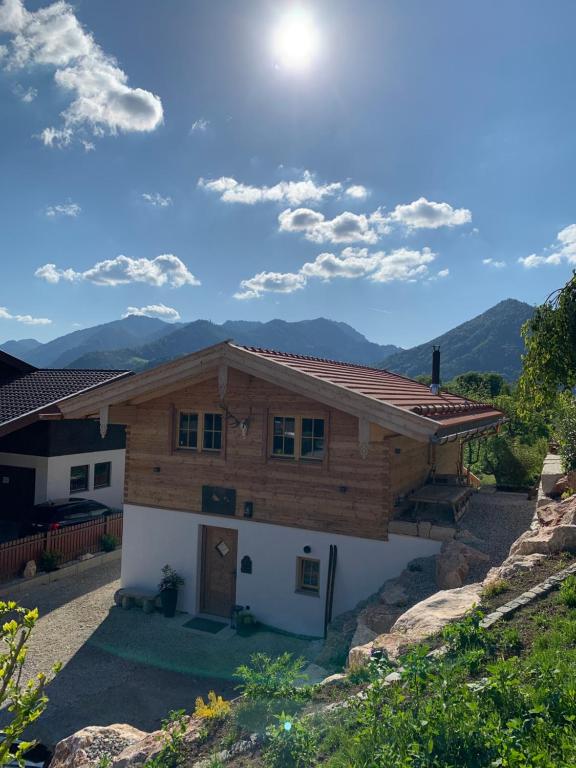 a house with a roof with mountains in the background at Chalet Ruhpolding Bayern in Ruhpolding