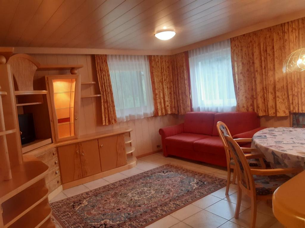 sala de estar con sofá rojo y mesa en Alpen Ferienwohnung Ill, en Lappago