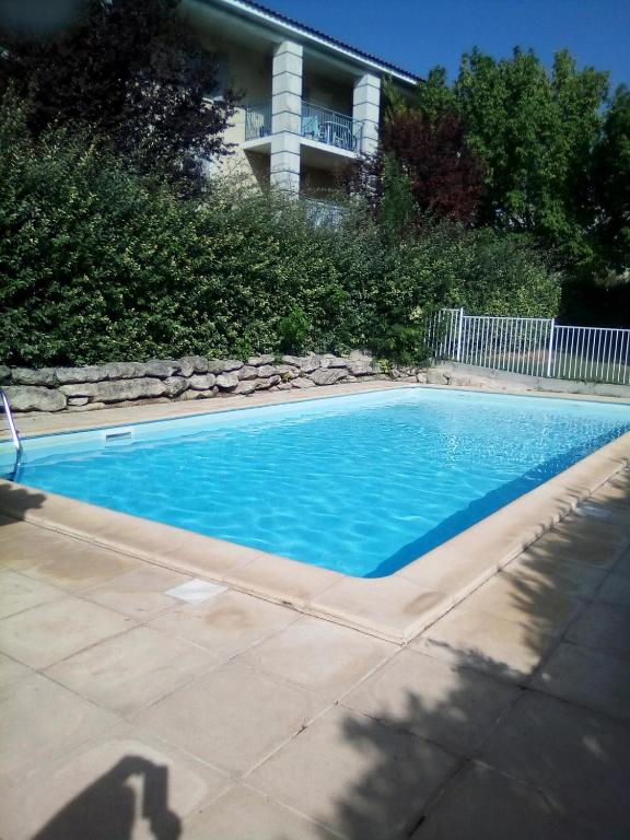 une piscine avec de l'eau bleue devant une maison dans l'établissement Appartement 1 chambre avec Piscine, à Uzès
