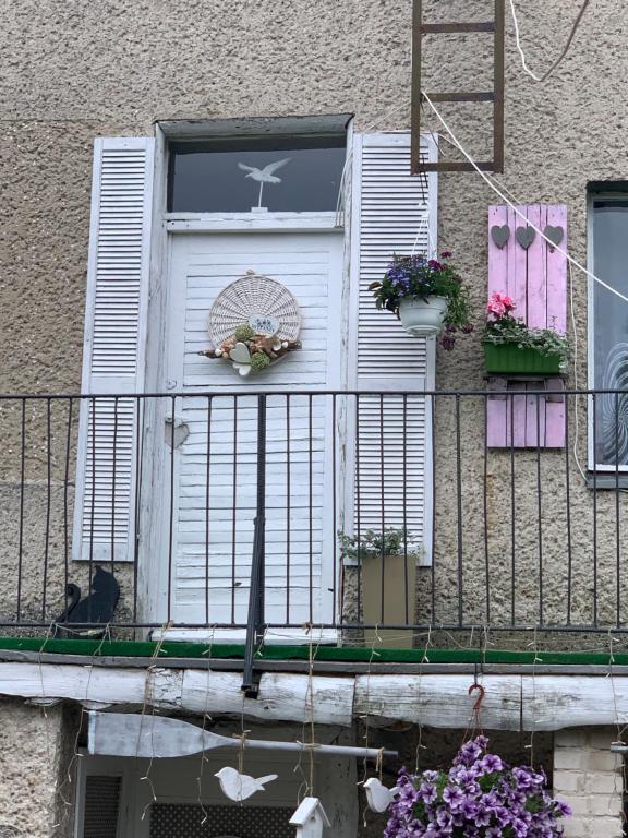 a cat sitting on a balcony with a window at Tififi jak na Włoskiej prowincji in Pobierowo