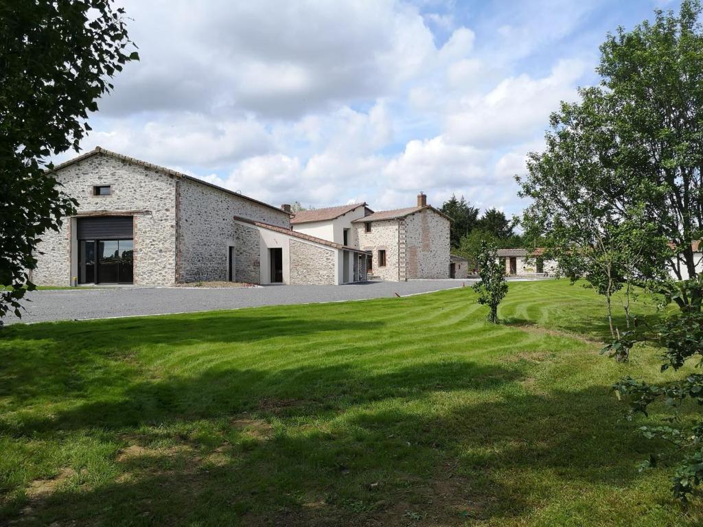 a house with a green lawn in front of it at LA GRANDE THIBAUDIERE in La Plaine