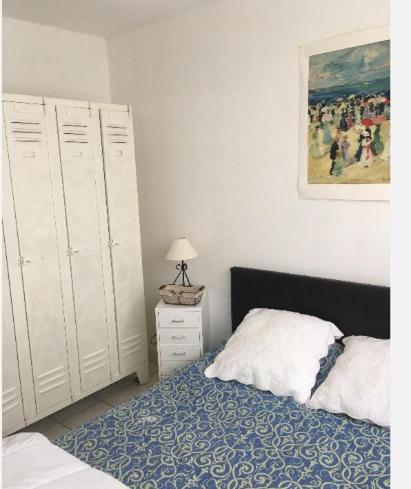 a bedroom with a bed and a painting on the wall at Appartement sympa Arcachon in Arcachon