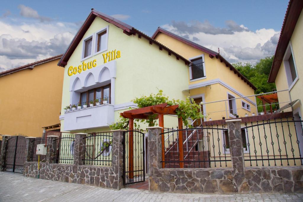 un edificio con una valla delante en Cosbuc Residence & Villa, en Sighişoara