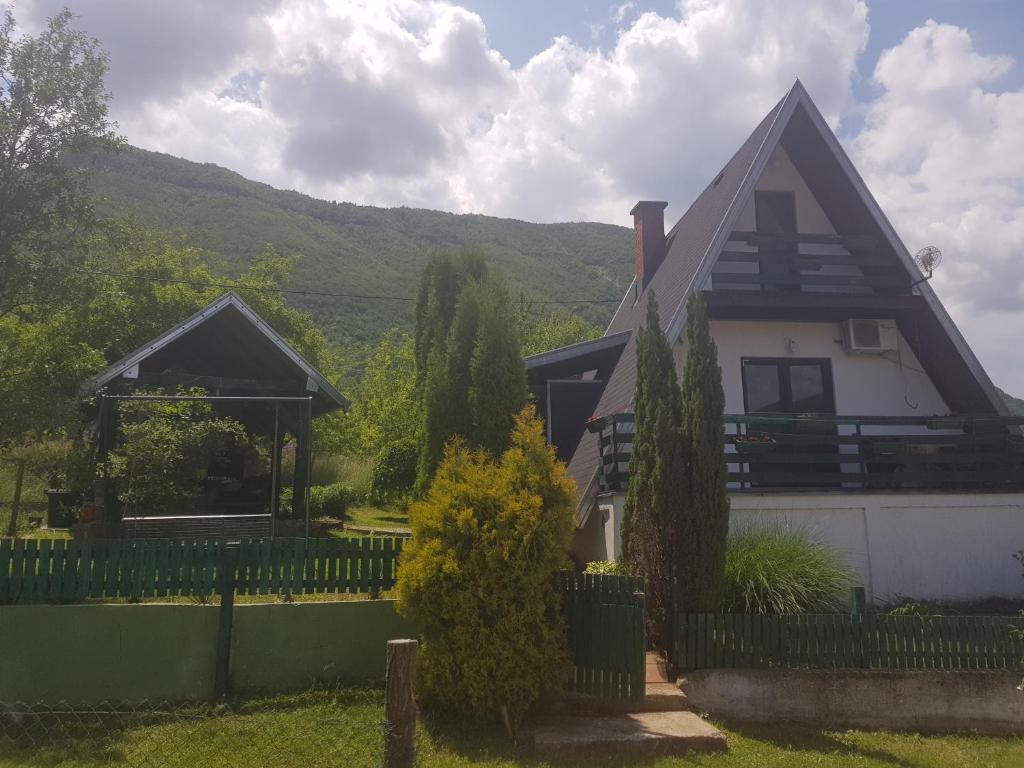 ein Haus mit einem Zaun davor in der Unterkunft Kuća za odmor Andrej in Perućac