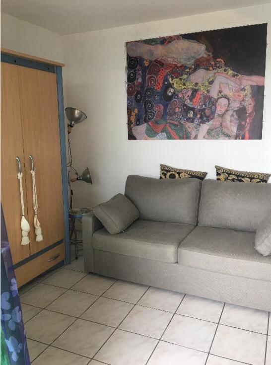 a living room with a couch and a painting on the wall at Appartement sympa Arcachon in Arcachon