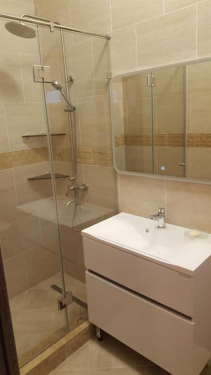 a bathroom with a sink and a glass shower at U Morya Guesthouse in Yevpatoriya