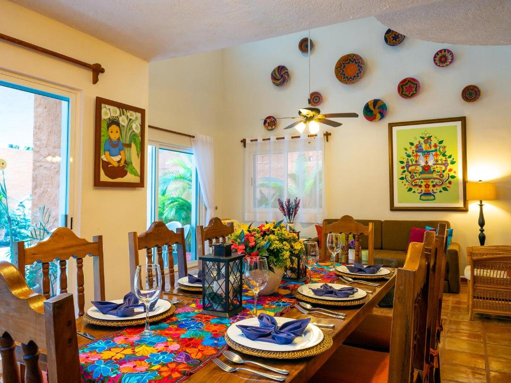 a dining room with a wooden table and chairs at Casa Mulder in Puerto Morelos
