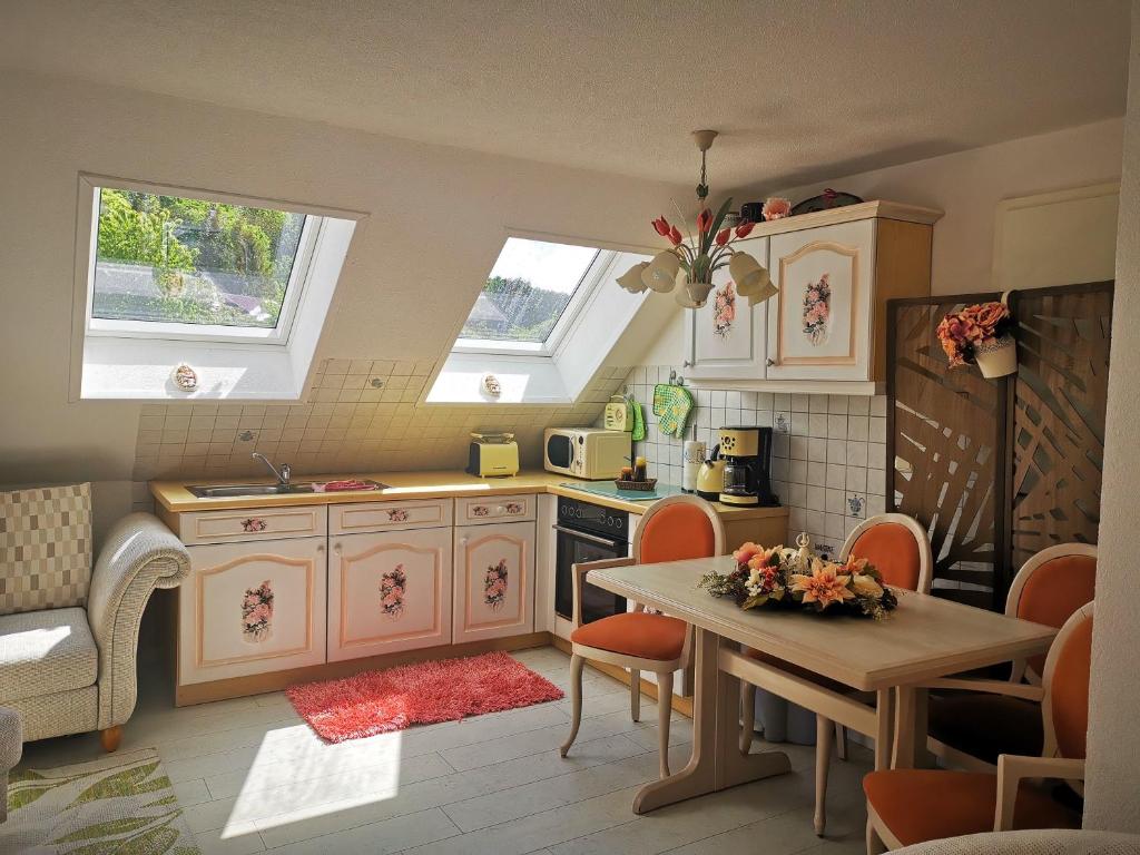 cocina con armarios blancos, mesa y sillas en Rustikale Wohnung, en Patzig