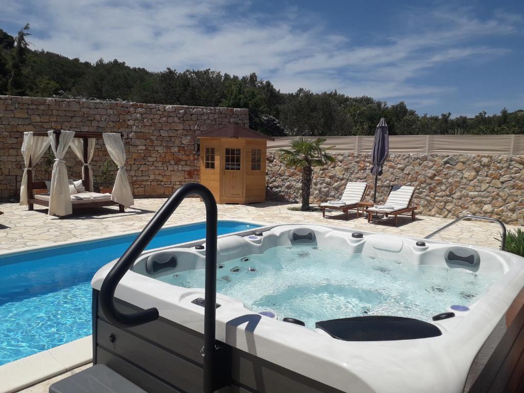 a jacuzzi tub sitting next to a pool at Villa Roza Murter in Murter