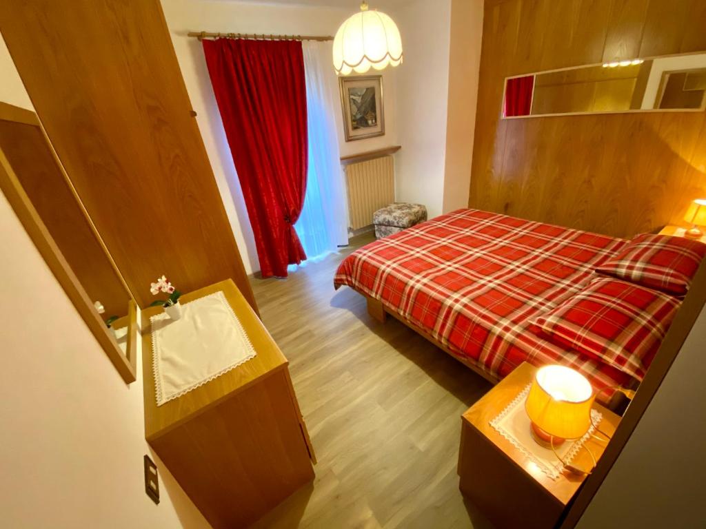 1 dormitorio con 1 cama y lavamanos. en Villa Tisot, en Fiera di Primiero