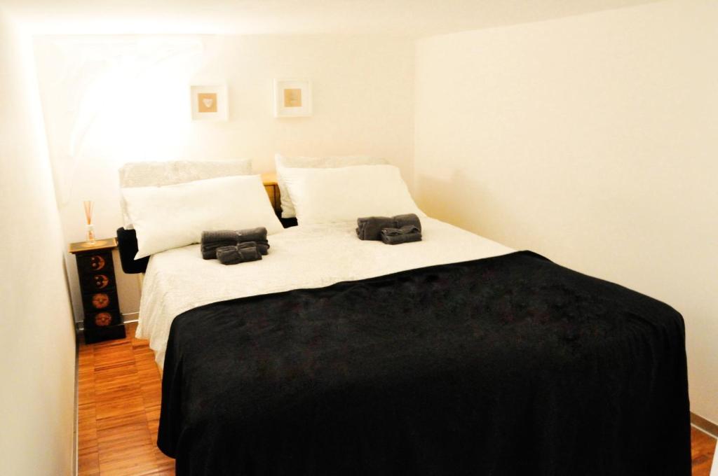 ein Schlafzimmer mit einem großen Bett mit zwei schwarzen Kissen in der Unterkunft Ciro [Piazza Unità Italia] in Triest
