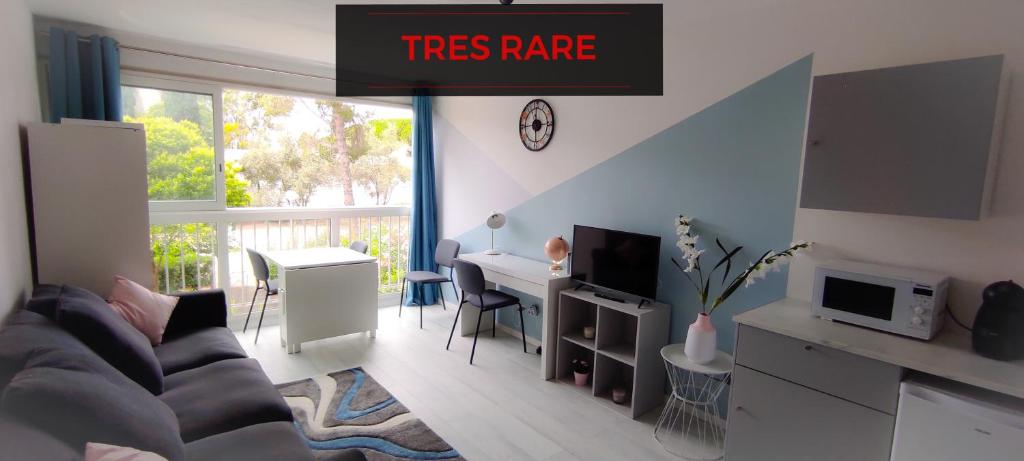 uma sala de estar com um sinal raro de árvore na parede em Studio 26m2 centre ville rénové avec parking privé em La Grande-Motte