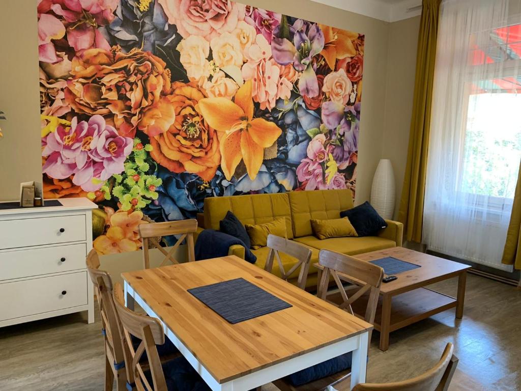 a living room with a table and a flower wall at Apartmán Galerie in Děčín